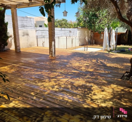 wooden deck with shadows from trees and pergola